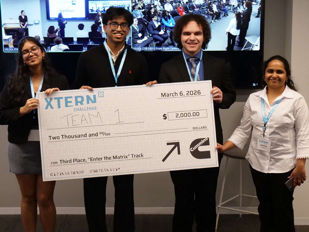 Team 1 poses with a ceremonial $2,000 check for third place in the Enter the Matrix track at the 2026 Xtern Challenge. Team members are Avani Kabra of Purdue University, Sahmey Raiyan Khan of DePauw University, and Allen Merrill of the University of Indianapolis.