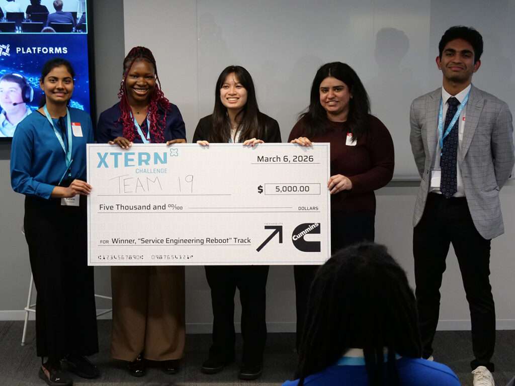 Team 19 poses with a ceremonial $5,000 check after winning first place in the Service Engineering Reboot track at the 2026 Xtern Challenge. Team members are Karuna Saravanan, Inioluwa “Tina” Oyatobo, and Kyra Truong of Indiana University Indianapolis, and Mannandeep Caur and Nishad Patel of Purdue University.