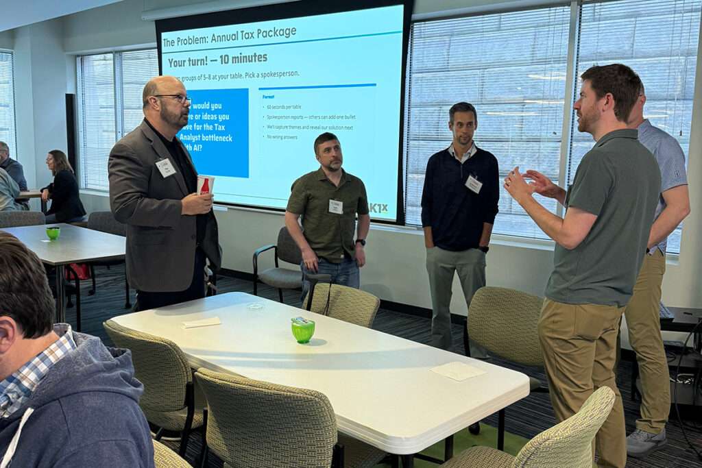 Attendees discuss potential AI solutions during a small-group exercise at the May AI Innovation Network event.