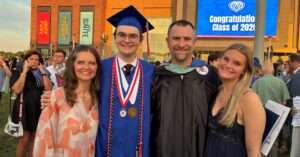 Nick Fishel stands with family at son's high school graduation.