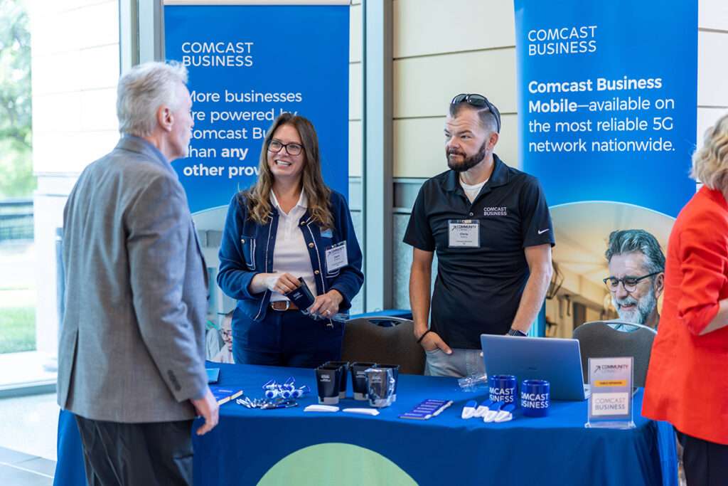 Attendees speak with Comcast Business representatives at a sponsor booth during TechPoint’s Community Connect event.