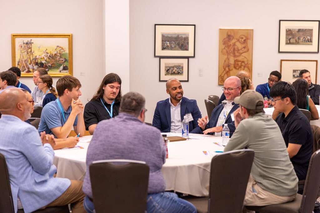 Community Connect attendees from different organizations and backgrounds participate in a small-group discussion around a table.