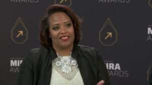 Akilah Darden, founder of The Darden Group LLC, speaks during an interview in front of a Mira Awards backdrop.