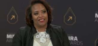 Akilah Darden, founder of The Darden Group LLC, speaks during an interview in front of a Mira Awards backdrop.