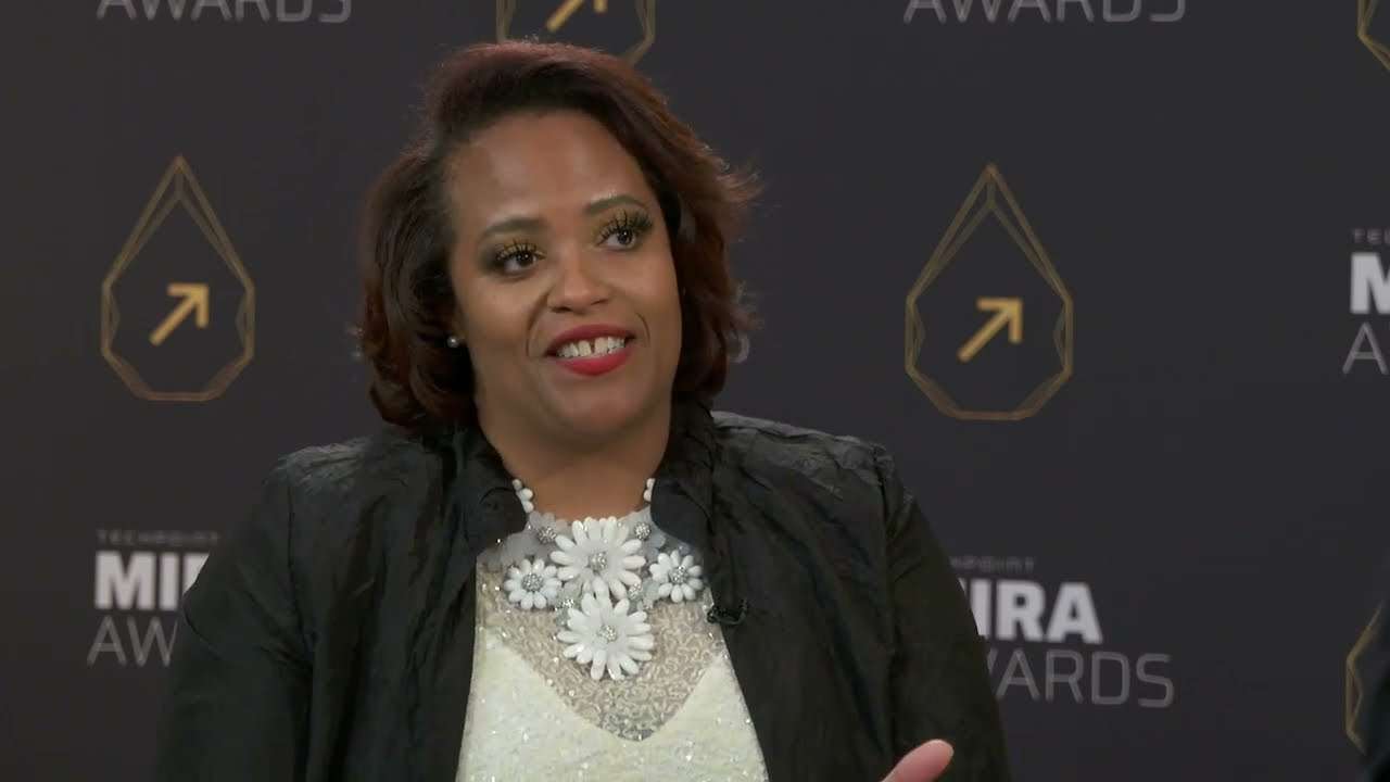 Akilah Darden, founder of The Darden Group LLC, speaks during an interview in front of a Mira Awards backdrop.