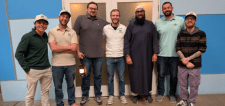 Seven members of the Lemhi team pose together, with several wearing Lemhi-branded shirts and hats.