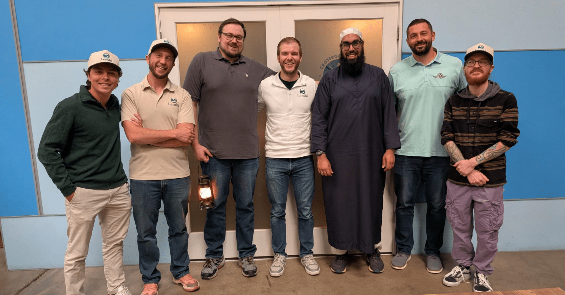 Seven members of the Lemhi team pose together, with several wearing Lemhi-branded shirts and hats.